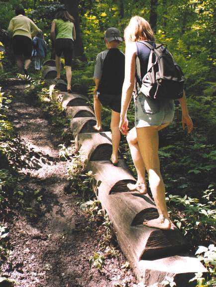 Menschen auf einer Holzstation des Barfußpfads Nienhagen, Archivaufnahme von 2003